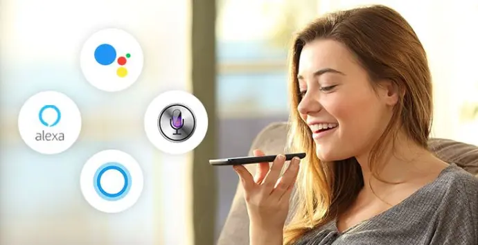  A person saying “Alexa, turn on the lights” to a smart speaker on a table.